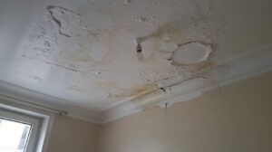 Plafond d'appartement taché par l'humidité et peinture cloquée après un dégât des eaux