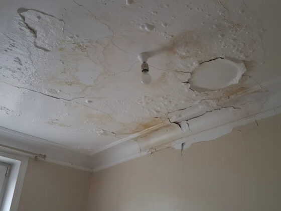 Plafond d'appartement taché par l'humidité et peinture cloquée après un dégât des eaux