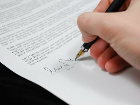 Main signant un document au stylo plume